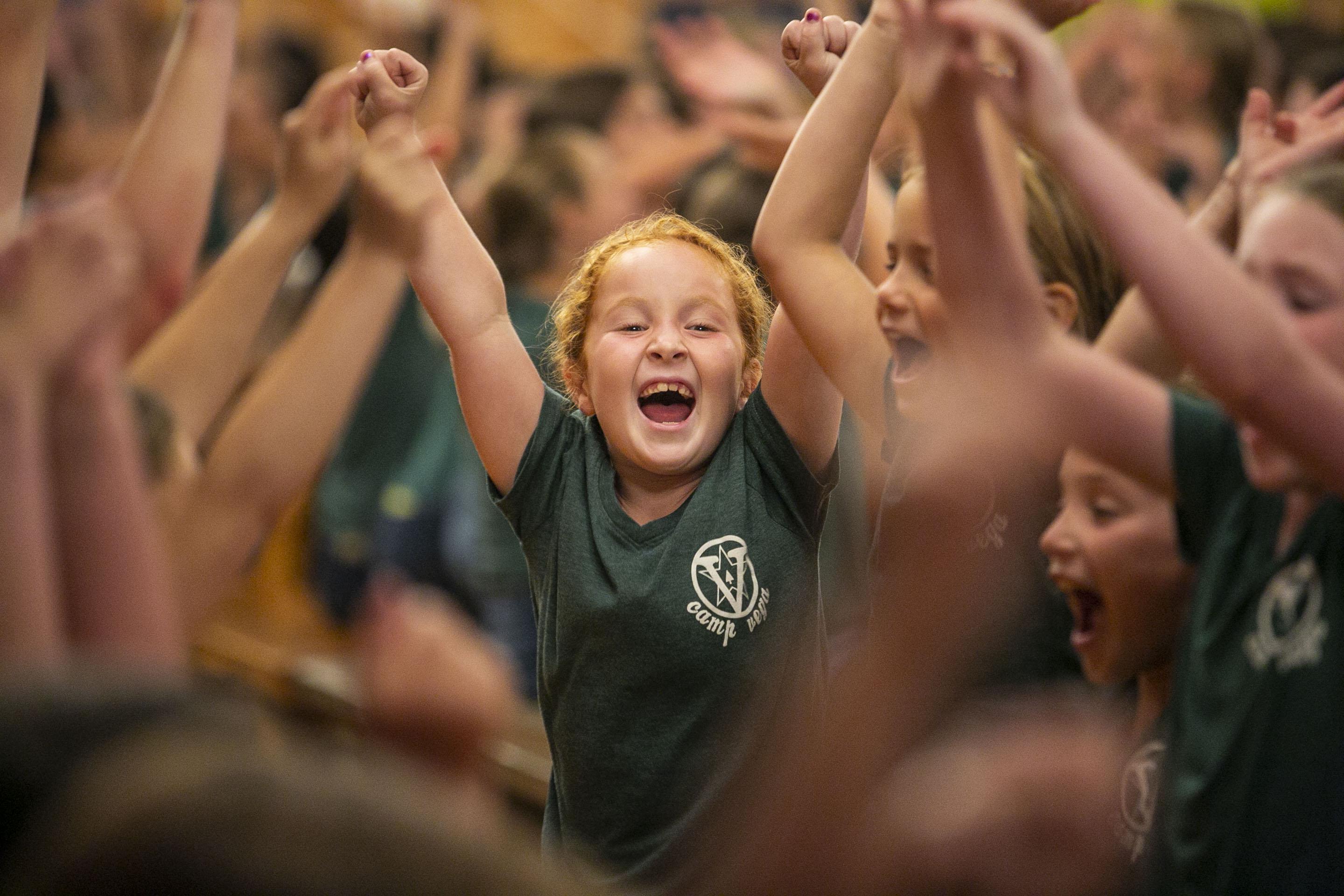 A camper cheering with friends at Vega