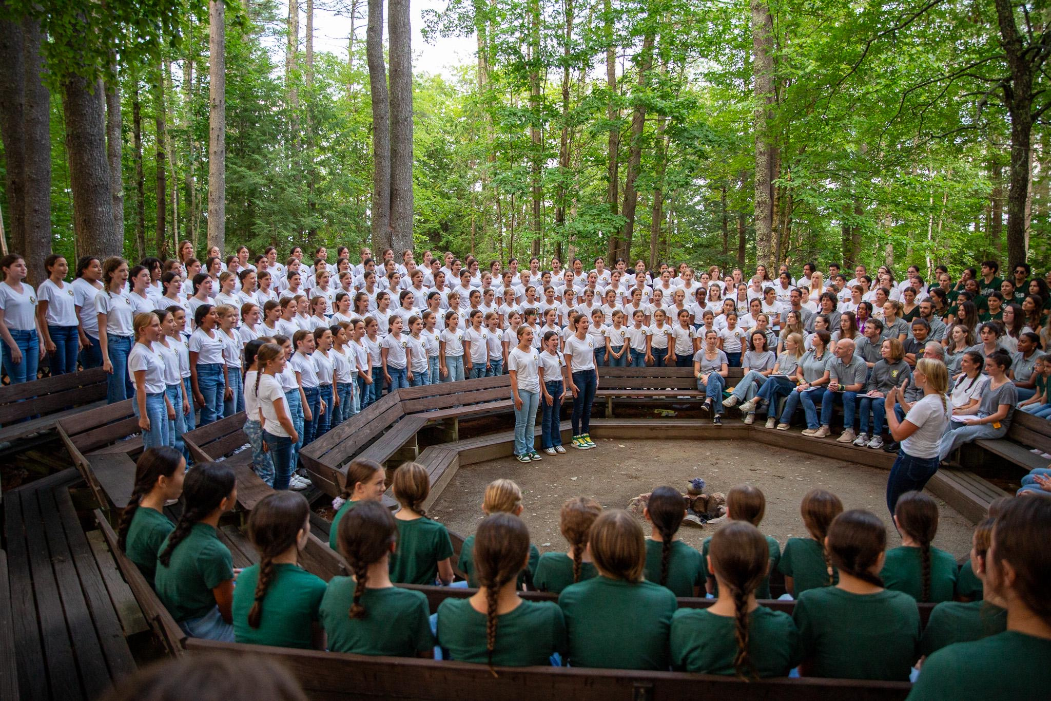 Campers singing together among the trees at Sunset Circle
